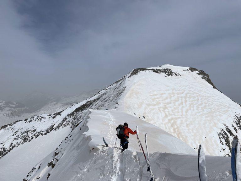 Skieur progressant sur l'arête sommitale enneigée