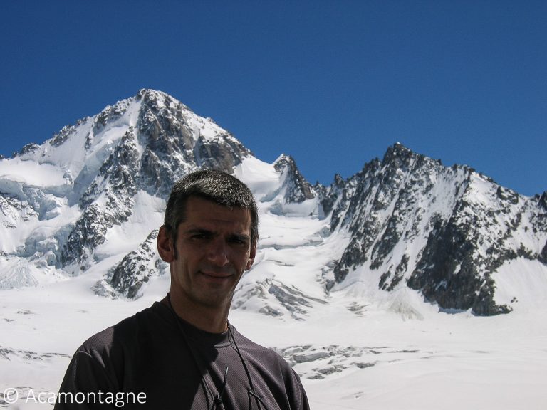 Portrait en montagne devant un sommet enneigé et son glacier, sous un ciel bleu profond