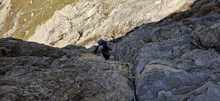 Grimpeur dans un passage de dalles équipé d'une corde fixe