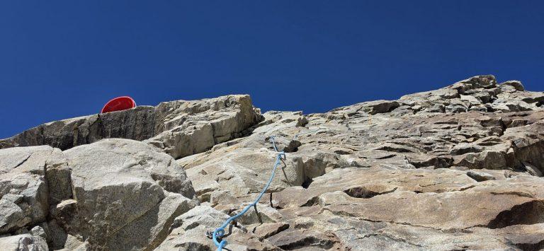 Dernières dalles équipées de cordes fixes, l'extrémité rouge du bivouac Gervasutti visible en haut