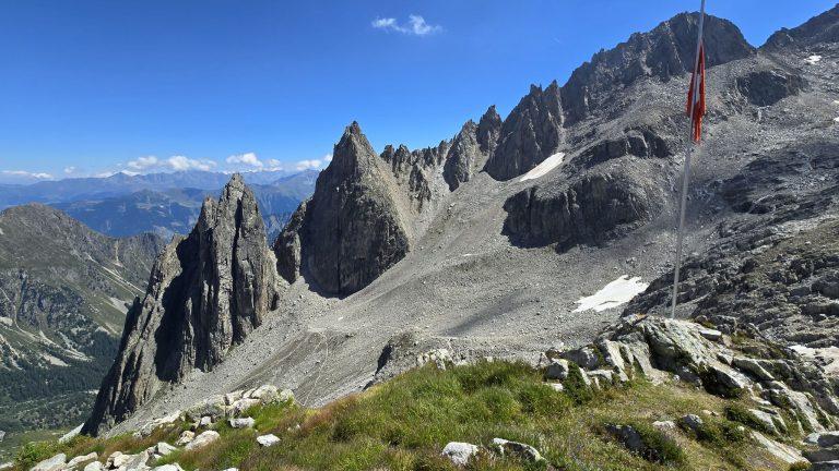 Drapeau suisse devant les tours rocheuses, le Val Ferret en contrebas