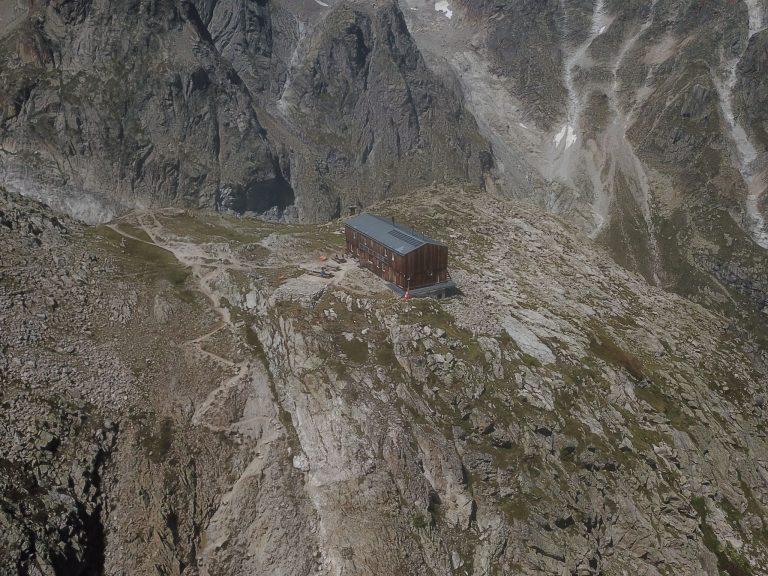 Vue au drone de la cabane sur l'éperon rocheux, entre les pentes d'éboulis