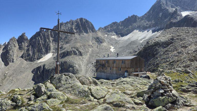 La croix sur les rochers et la cabane de Saleinaz, au pied des sommets