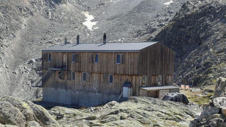 La cabane de Saleinaz, grand bâtiment en bois posé sur les dalles, au pied des éboulis