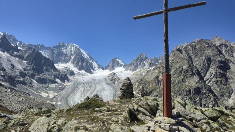 Grande croix en bois et cairn face au glacier de Saleina et aux sommets enneigés