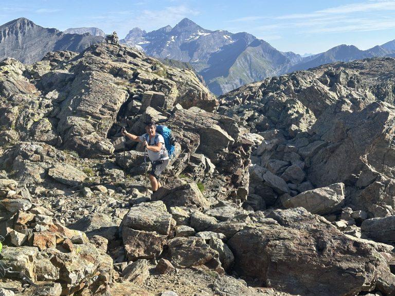 Randonneur dans un chaos de blocs sous le col de la Terrasse, sommets en arrière-plan