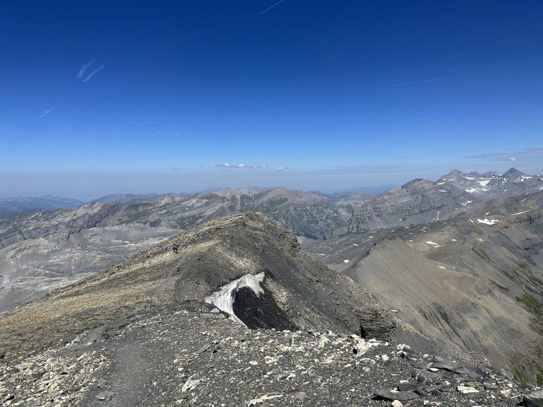 L'arête parcourue vue d'en haut, une corniche de neige et les sommets du Valais