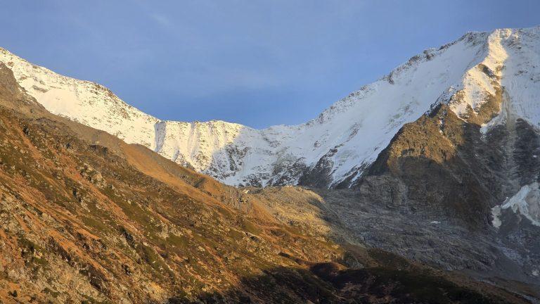 Crêtes enneigées des Dômes de Miage au-dessus du vallon, versants dorés par le soleil de fin d'après-midi