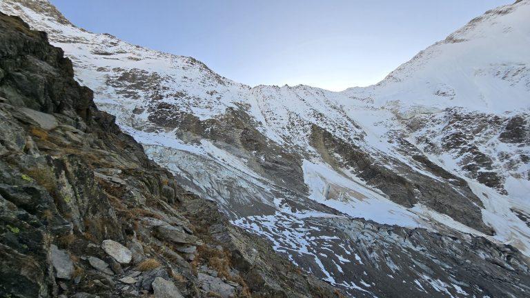 Langue glaciaire crevassée sous les faces enneigées, vue depuis les rochers