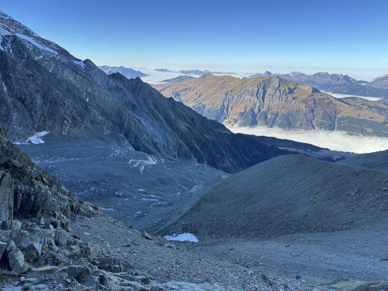 Vue plongeante sur la moraine du glacier de Miage, la mer de nuages et les sommets au loin