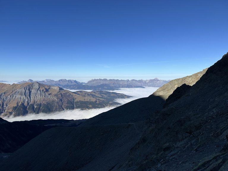 Mer de nuages sur les vallées, crêtes au soleil, versant à l'ombre au premier plan