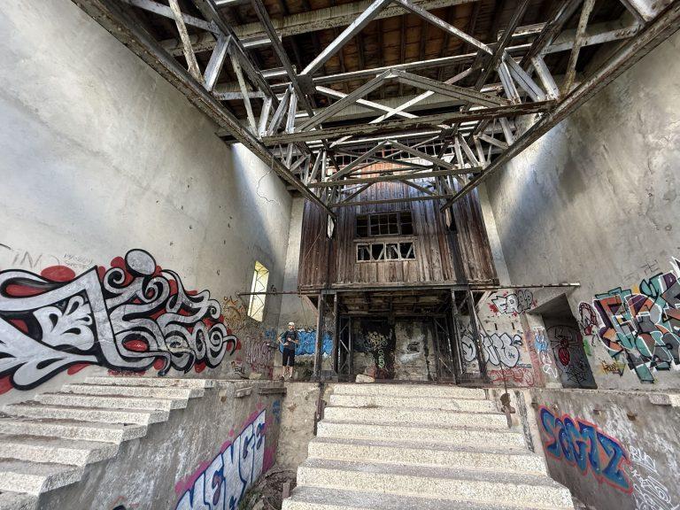 Grand hall de la gare de La Para, escaliers de pierre et graffitis sous la charpente métallique