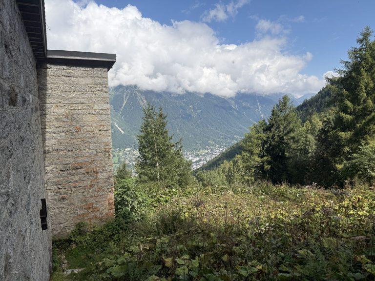 Mur de pierre de la gare et vue plongeante sur la vallée de Chamonix, sous les nuages