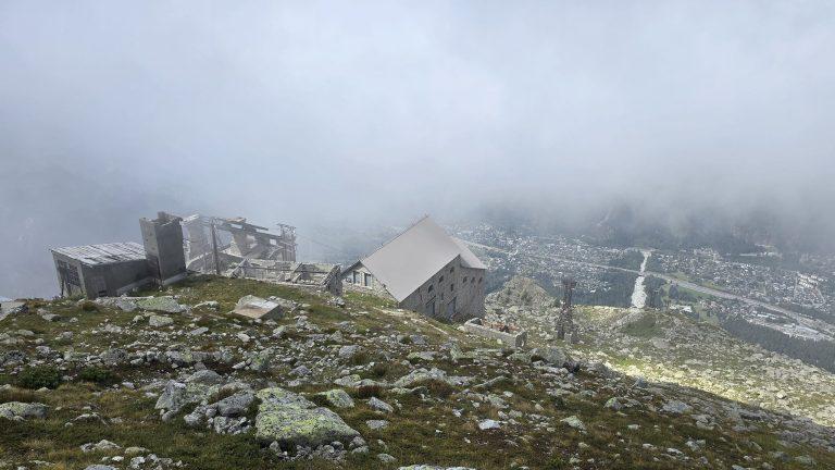 Les bâtiments de la station des Glaciers sur leur crête, Chamonix en contrebas sous les nuages