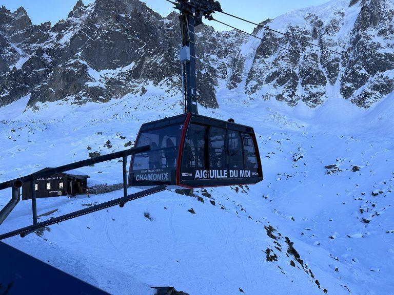 Cabine rouge et noire du téléphérique de l'Aiguille du Midi, devant les parois enneigées
