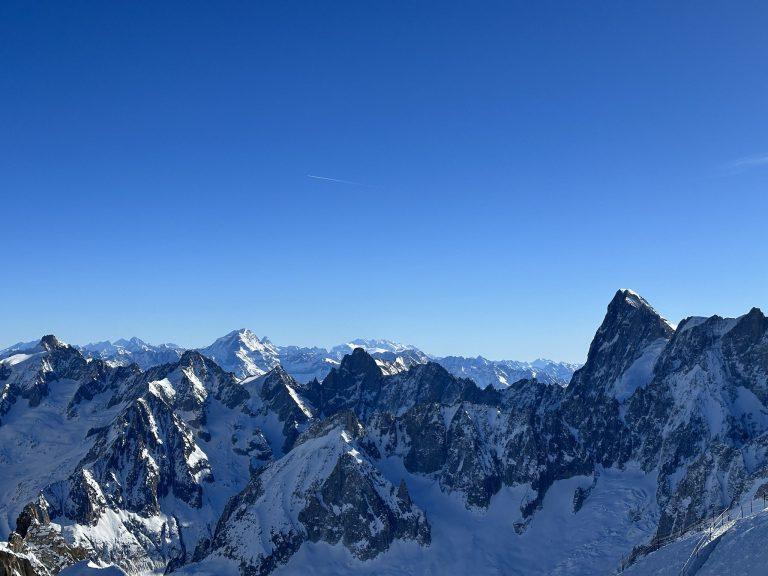 Crêtes rocheuses enneigées du massif du Mont-Blanc et, au loin, les sommets des Alpes