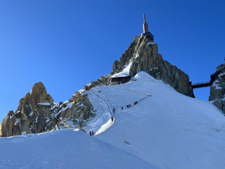 Des skieurs descendent l'arête balisée sous la station de l'Aiguille du Midi