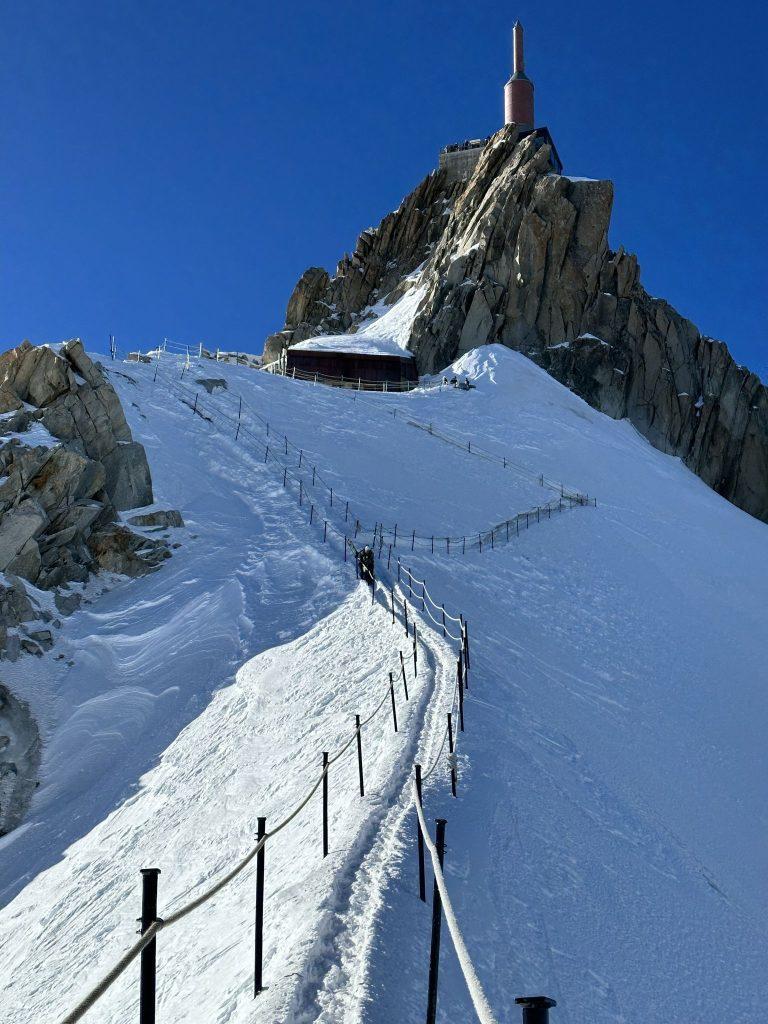 La station de l'Aiguille du Midi au sommet de son éperon, l'arête balisée de cordes en contrebas