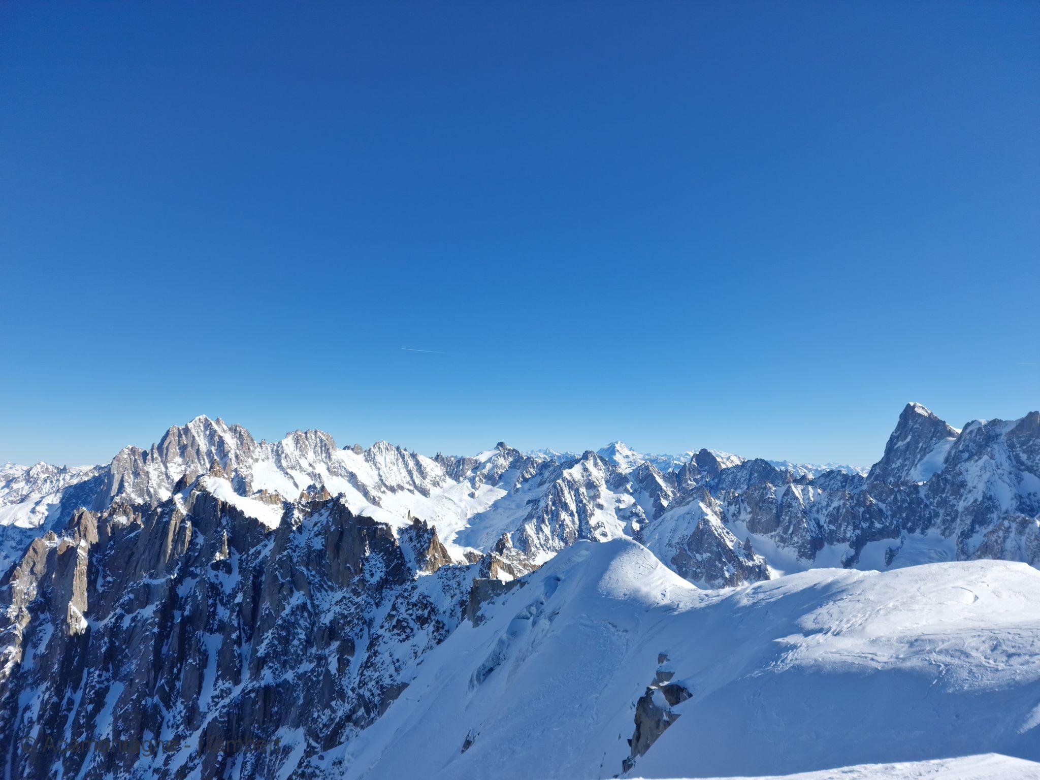 Panorama sur les aiguilles et les sommets enneigés au départ de la Vallée Blanche