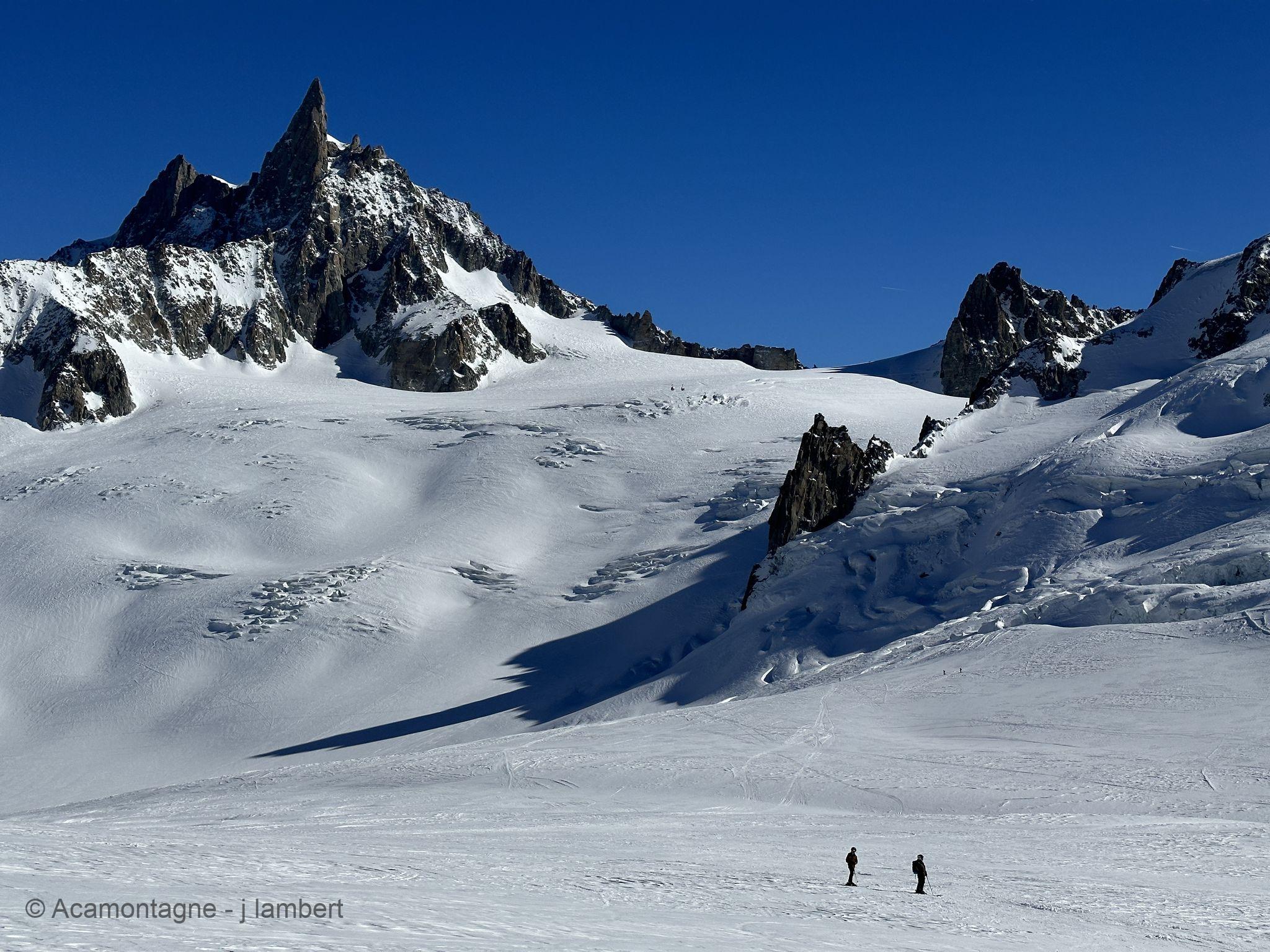 Deux skieurs minuscules sur le glacier du Géant, la Dent du Géant en arrière-plan