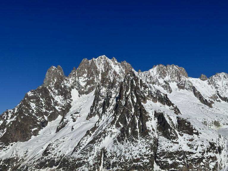 Grande montagne de granit et de neige aux arêtes découpées, sous un ciel bleu