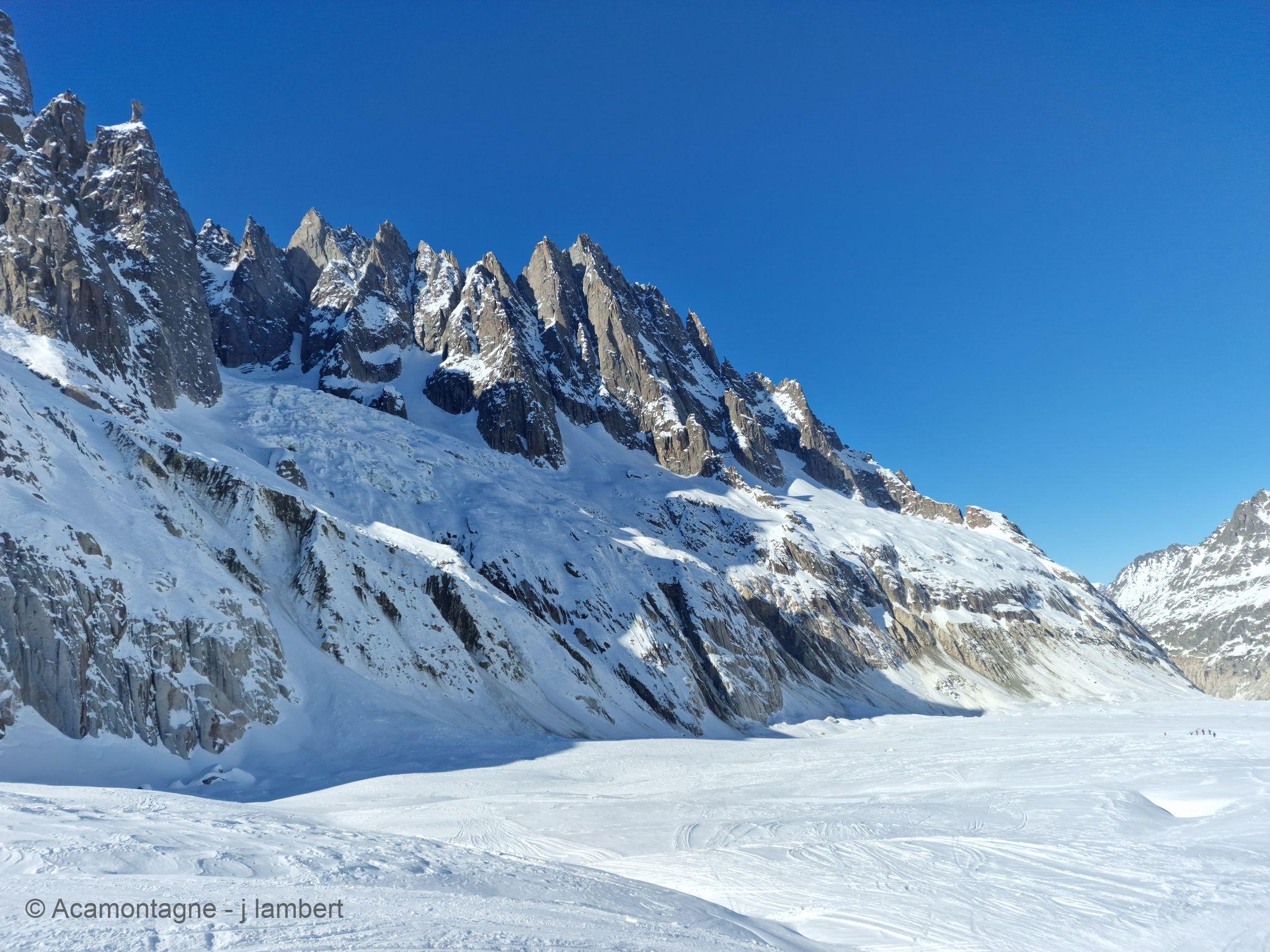 Les aiguilles de Chamonix dominant la Mer de Glace, des skieurs au loin