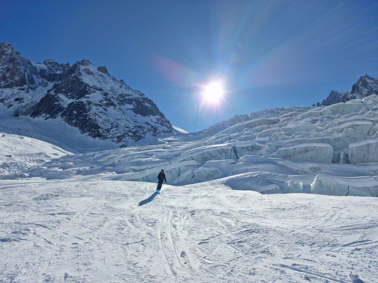Un skieur descend le glacier devant une barre de séracs